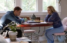 a man and woman sitting at a table playing chess