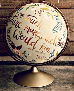 a globe with words written on it sitting in front of a wooden wall