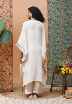 Editor's Note Featuring an ivory kaftan with v-neckline drape which is finished with metallic border is teamed up with linen pants Color: Ivory Fabric: Cotton Occasion: Resort Components: Kaftan and pants Disclaimer: Product color may slightly vary due to photographic lighting sources or your monitor setting. Care: Dry Clean Only About the Designer Rishi & Vibhuti label combines traditional elements with modern aesthetic uniquely to create chic occasion wear for women with a fine choice. The glo Kaftan With Pants, Ivory Drapes, Kaftan Sleeves, Kaftan Tunic, Personal Shopping Service, Fashion App, Pant Set, Straight Pants, Linen Pants