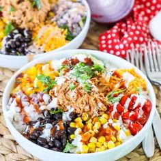 two white bowls filled with different types of food on top of a woven place mat