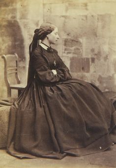 an old photo of a woman sitting on a chair