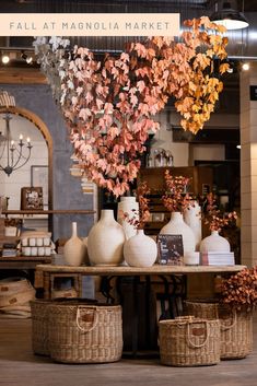 an arrangement of vases and flowers on a table in a room with other items