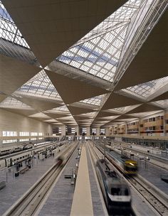 a train traveling through a train station under a skylight