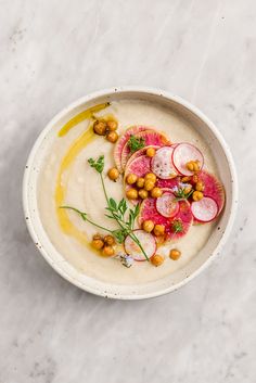 a white bowl filled with food and garnished with radishes on top