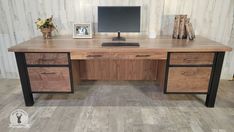 a wooden desk with two drawers and a computer monitor on it's standup