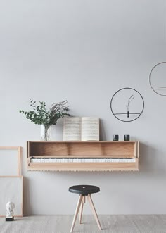 a piano sitting on top of a wooden shelf next to a vase filled with flowers