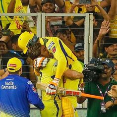 two men in yellow and blue uniforms are hugging each other while people look on from the stands