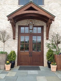 the front entrance to a home with potted plants