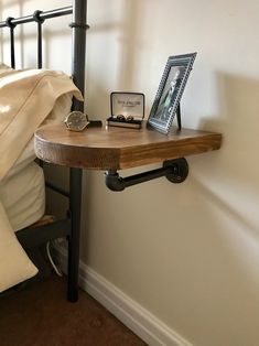 a wooden table sitting on top of a bed next to a metal frame headboard