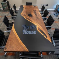 a conference table with chairs around it and the words the art house painted on it