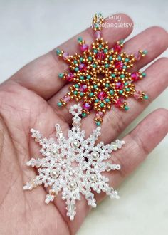 a hand holding a snowflake ornament in it's palm