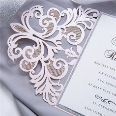 the wedding card is made with laser cut paper and embellishments on it