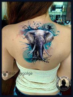 an elephant tattoo on the back of a woman's shoulder and neck, with blue ink