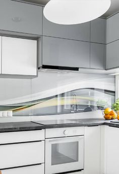 a modern kitchen with white cabinets and stainless steel appliances, along with fruit on the counter