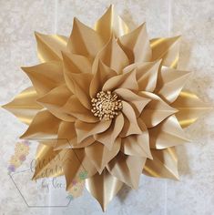 a large paper flower is on the wall in front of tile flooring and walls