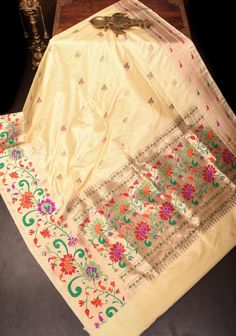 Elevate your wardrobe with the timeless sophistication of this Beige Pure Banarasi Katan Silk Saree, a stunning example of traditional craftsmanship and elegance. The saree features a classic beige hue that exudes a sense of understated luxury and versatility, making it an ideal choice for various occasions. Crafted from pure Katan silk, it offers a smooth, rich texture and a graceful drape that enhances its opulent appeal. Adorned with intricate zari motifs, the saree showcases delicate patterns that add a layer of artistry and refinement. The shimmering golden threads are meticulously woven into the fabric, creating a subtle yet captivating sparkle that enhances the saree's overall elegance. Complementing the exquisite motifs are Paithani-style borders, which introduce a touch of traditi Banarasi Katan Silk Saree, Katan Silk Saree, Saree Blouses, Understated Luxury, Katan Silk, Rich Textures, Classic Beauty, Silk Saree, Silk Sarees