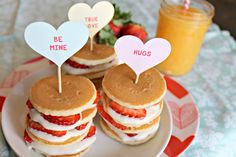 two heart shaped sandwiches on a plate with strawberries in the shape of hearts, and another sandwich that says be mine