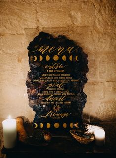 a table topped with a plaque next to two candles