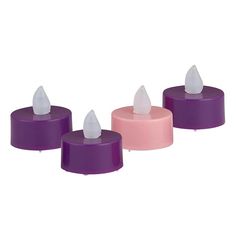 three small candles are sitting on top of each other, one is pink and the other is purple