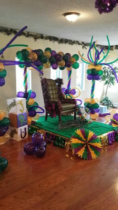 a room decorated with balloons, streamers and decorations for a mardi gras party