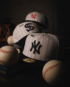 baseballs and caps sitting on top of a table next to eachother in the dark