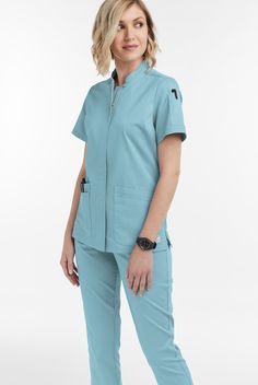 The UA Butter-soft Stretch women s 6-pocket collar neck zip front scrub top scrub top features a modern fit with a stand collar style and concealed zipper with top-button closure for a sleek appearance. There are 6 pockets total; 4 flattering angled roomy front pockets and 2 pen pockets on wearers left sleeve for easy access. It has a three piece back panel for fit and comfort, as well as side vents for ease of movement. Fabric is made up of 55 42 3 cotton poly spandex. • Modern fit • Stand Coll Cheap Gray Blouse For Workwear, Uniform Advantage Scrubs For Women, Scrubs Fashion, Medical Scrubs Fashion, Scrub Ideas, Medical Scrubs Outfit, Scrubs Outfit, Scrub Jackets, Medical Uniforms