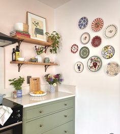 plates are hanging on the wall above a stove