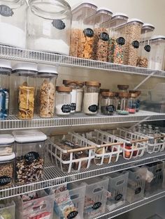 an organized pantry filled with lots of food and storage bins on the shelves in front of each other