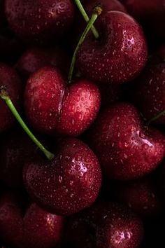 a close up view of some cherries with water droplets on them