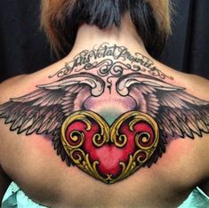 the back of a woman's neck with a heart and wings tattoo on it