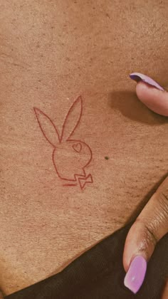 a woman's stomach with a drawing of a rabbit on it and her finger