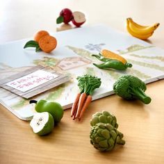 fruits and vegetables are arranged on a cutting board