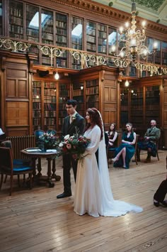 a bride and groom standing in front of a library