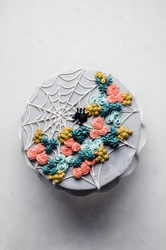 a cake decorated with flowers and spider web