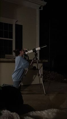 a man looking through a telescope at the night sky