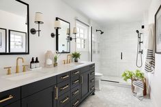 a bathroom with two sinks and mirrors on the wall next to a shower stall that has potted plants in it