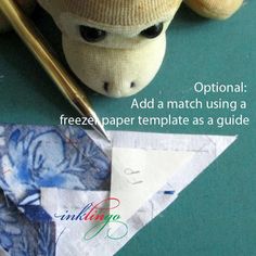 a stuffed animal sitting next to an origami piece with the caption option add a match using a freeze paper template as a guide