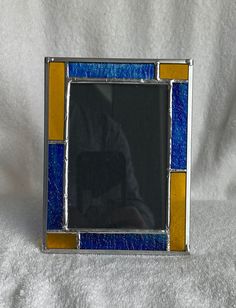 a small blue and yellow stained glass frame