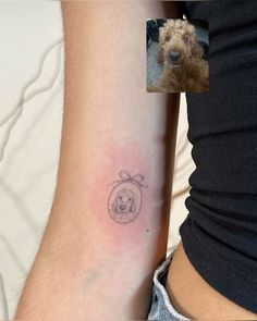 a small tattoo on the arm of a woman with a dog's head in it