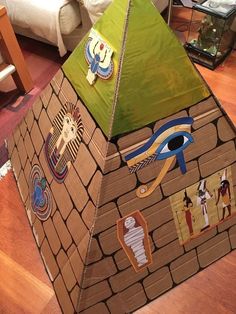 an egyptian pyramid made out of cardboard with stickers on the top and eyes painted on it