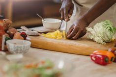 a person chopping up food on a cutting board