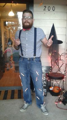 a man with glasses and suspenders standing in front of a store