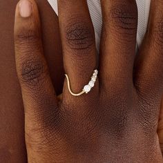 a close up of a person's hand with a gold ring on their finger