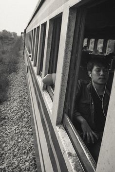 a boy is looking out the window of a train