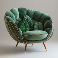 a green velvet chair with gold trimmings and large leaves on the back, in front of a gray background