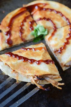 several slices of pizza sitting on top of a metal rack with sauce drizzled over them