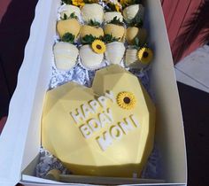 a box filled with lots of yellow and white cupcakes