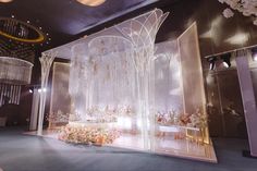 a wedding stage set up with flowers and chandeliers