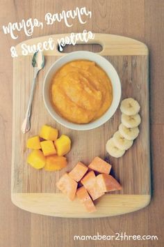 a wooden cutting board topped with bananas and oranges next to a bowl of peanut butter