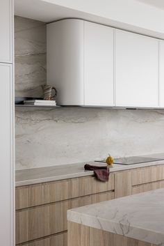 a kitchen with marble counter tops and white cabinets